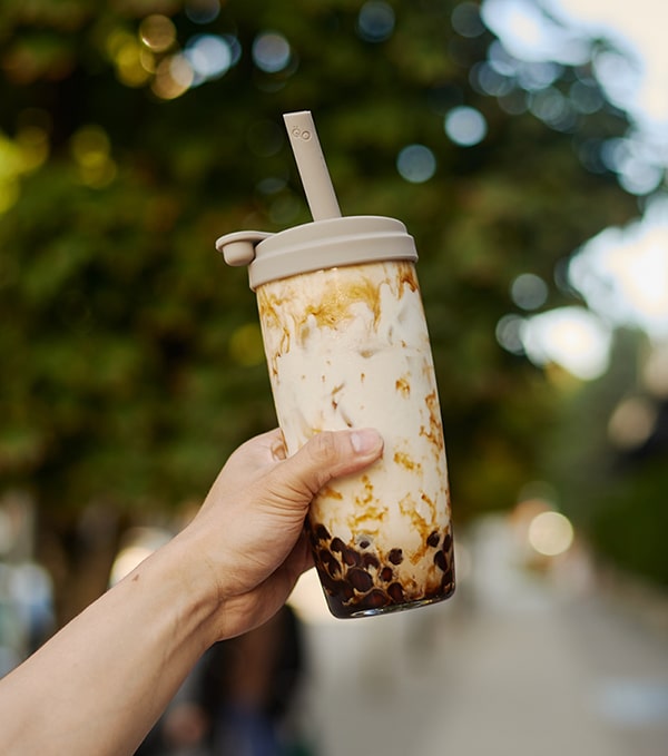 brown sugar bubble milk tea with pearls in a reusable cup and silicone straw