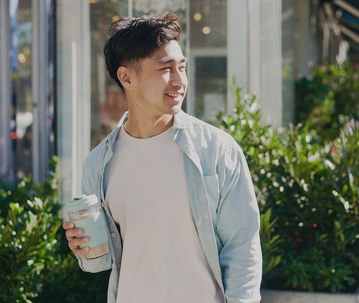 founder garren lau holding bobanc reusable glass cup with latte in green tea color