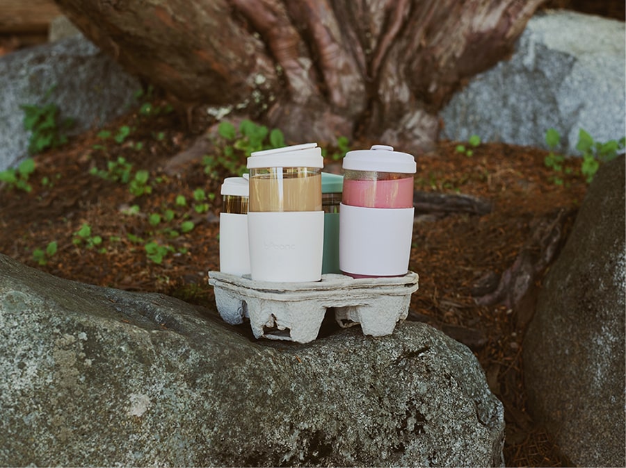trendy colored bobanc reusable cups in plastic-free cardboard cupholder in the forest